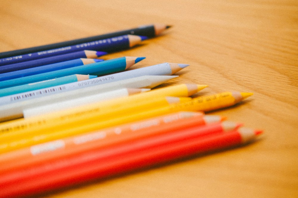 Colored pencils arranged on a wooden surface for a creative activity