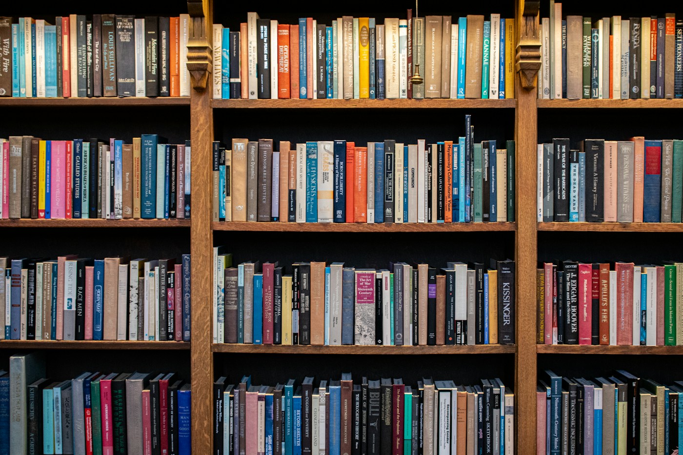 Colorful books on wooden library shelves